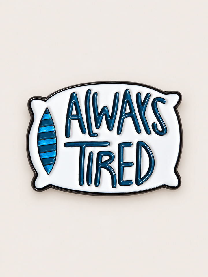 Always Tired Pillow Pin shown on a warm neutral background
