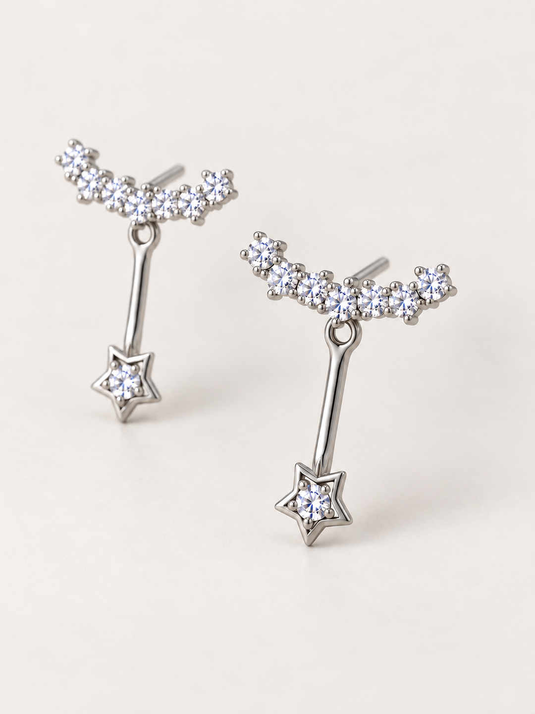 Crystal Star Ear Jacket Earrings shown angled on a warm neutral background