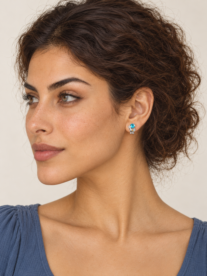 Astronaut Earrings on the viewer-right ear, showing the raised-arm astronaut