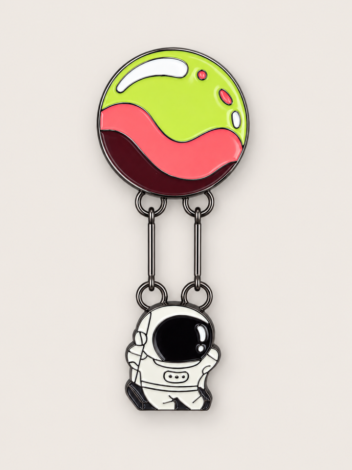 Astronaut Hanging from Planet Pin shown on a warm neutral background