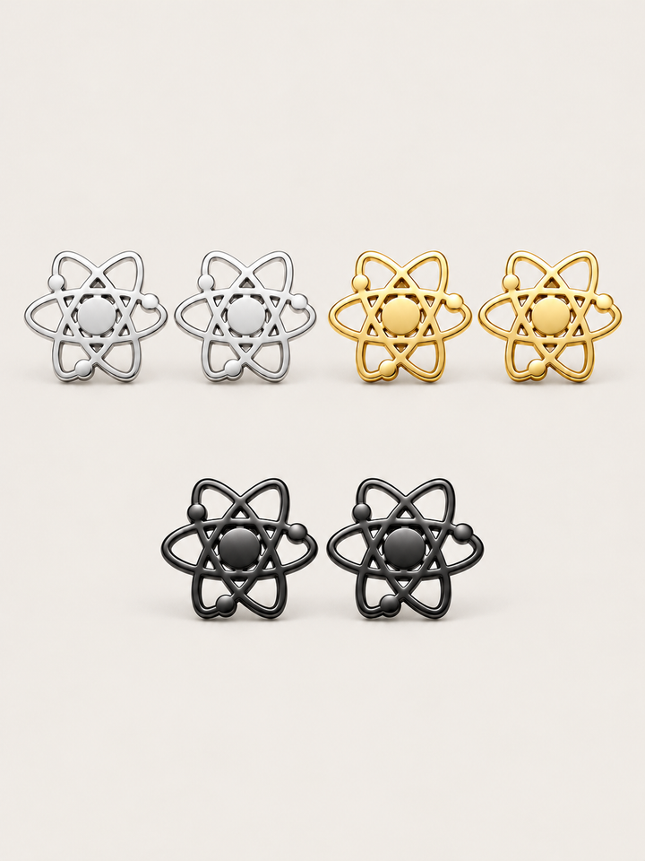Atom Stud Earrings in Silver, Gold and Black stainless steel on a warm neutral background
