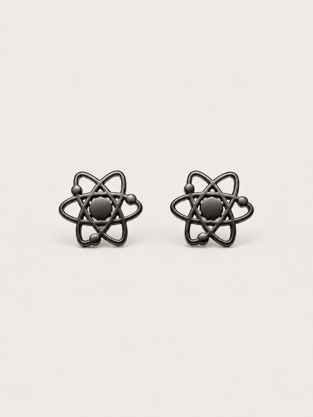 Atom Stud Earrings in black shown straight on on a warm neutral background