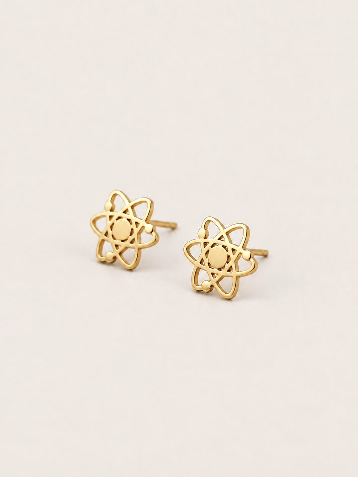 Atom Stud Earrings in gold shown at an angle on a warm neutral background