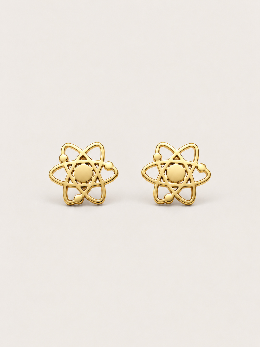 Atom Stud Earrings in gold shown straight on on a warm neutral background