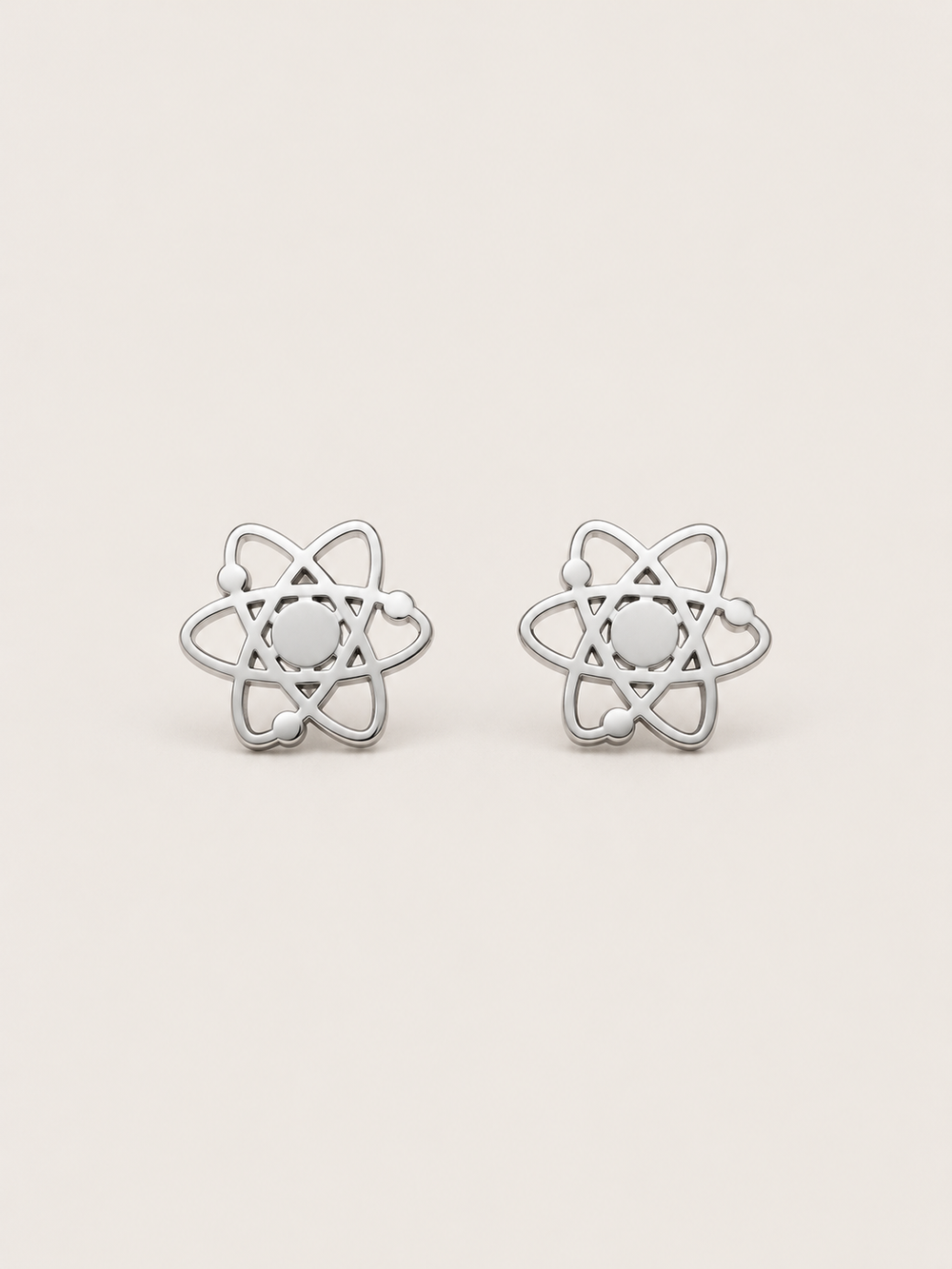 Atom Stud Earrings in silver shown straight on on a warm neutral background