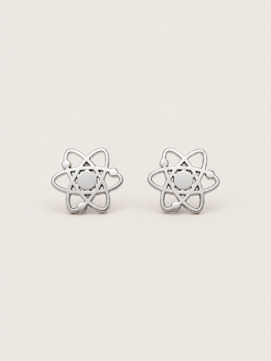 Atom Stud Earrings in silver shown straight on on a warm neutral background