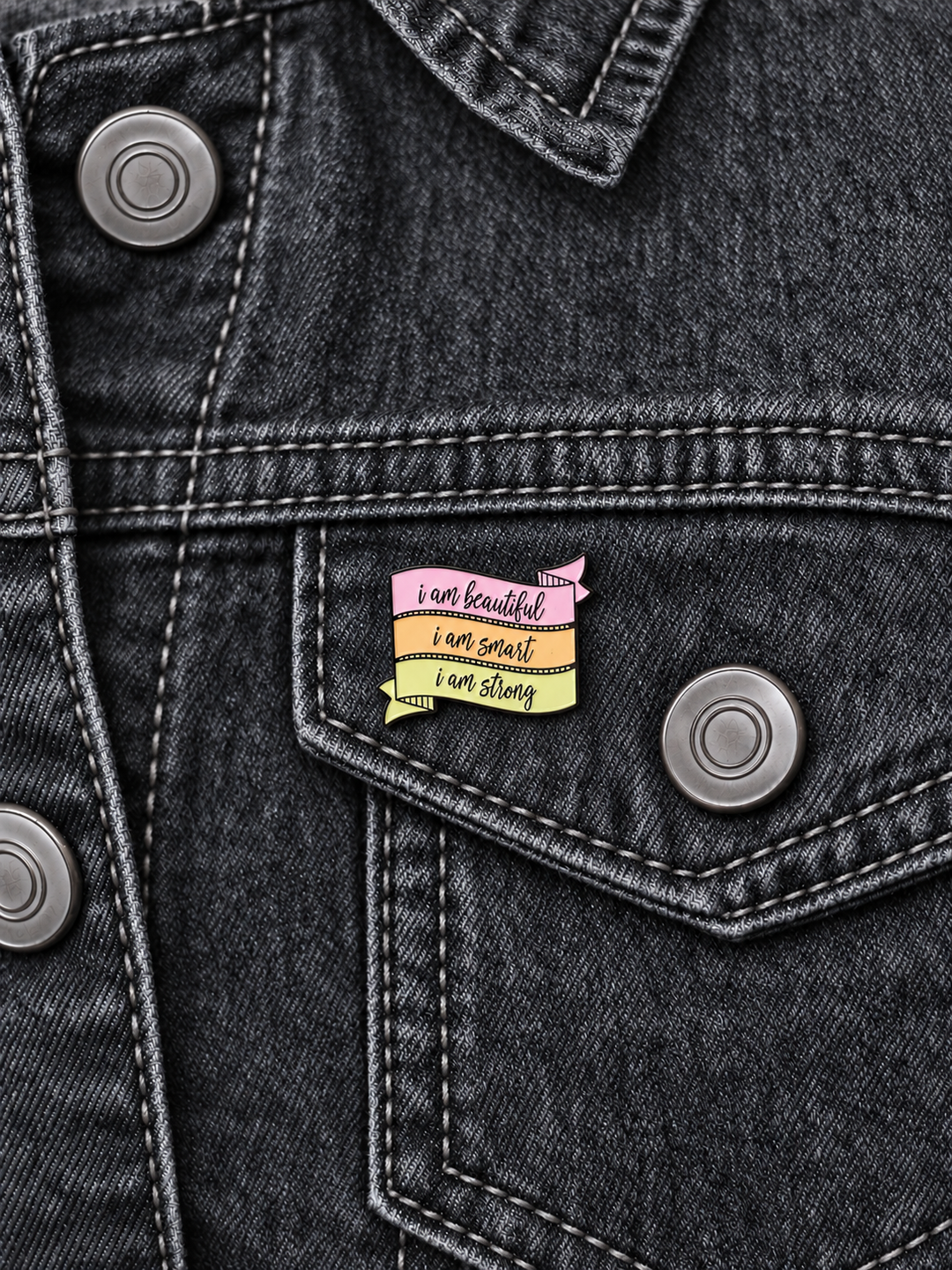 Beautiful Smart Strong Affirmation Pin displayed on a charcoal denim jacket beside a metal button