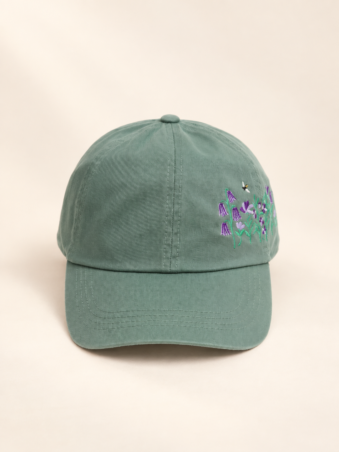 Front view of sage baseball cap with side flower and bee embroidery