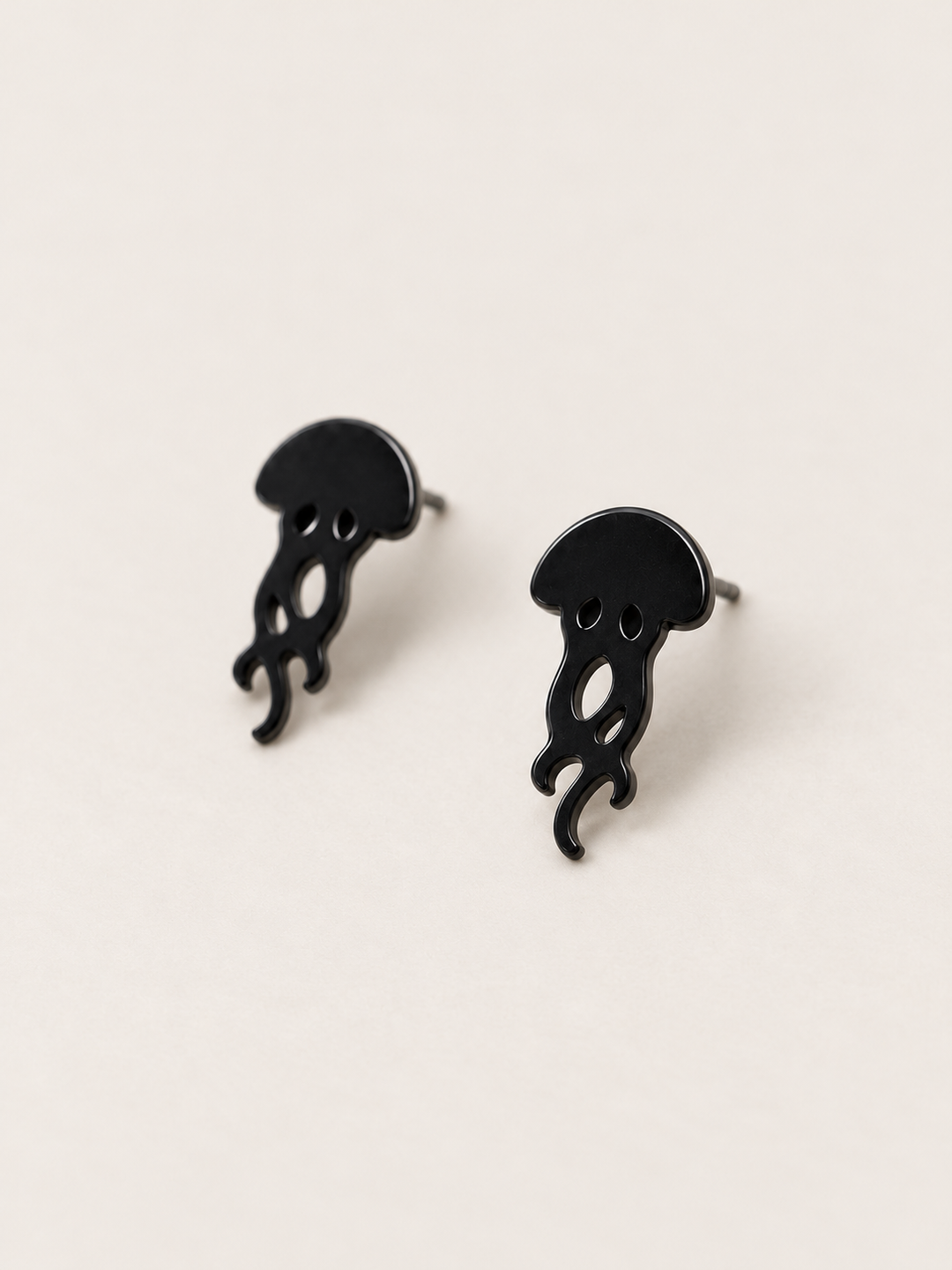 Black Jellyfish Stud Earrings shown angled on a warm neutral background