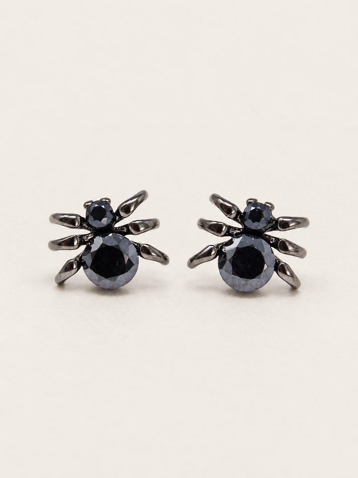 Black Spider Stud Earrings shown on a warm neutral background