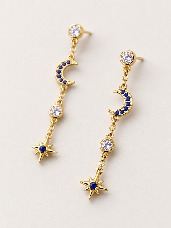 Blue Moon and Star Drop Earrings shown angled on a warm neutral background
