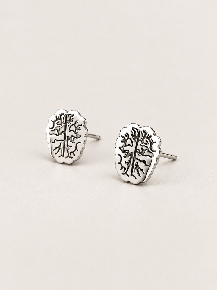Silver Brain Stud Earrings shown angled on a warm neutral background