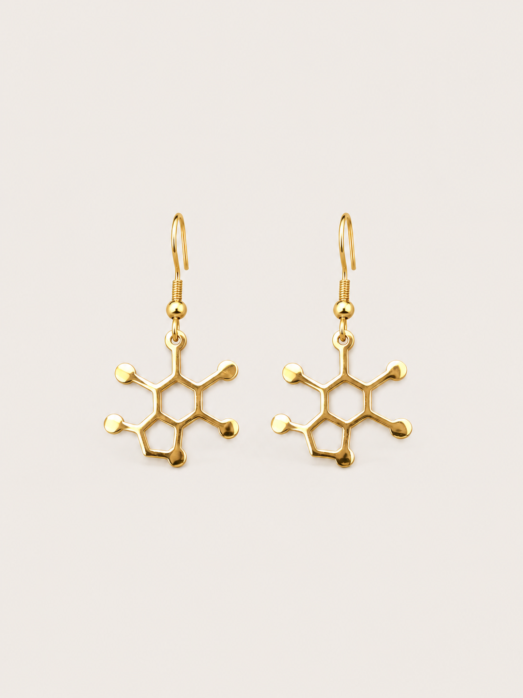 Gold Caffeine Molecule Earrings shown on a warm neutral background