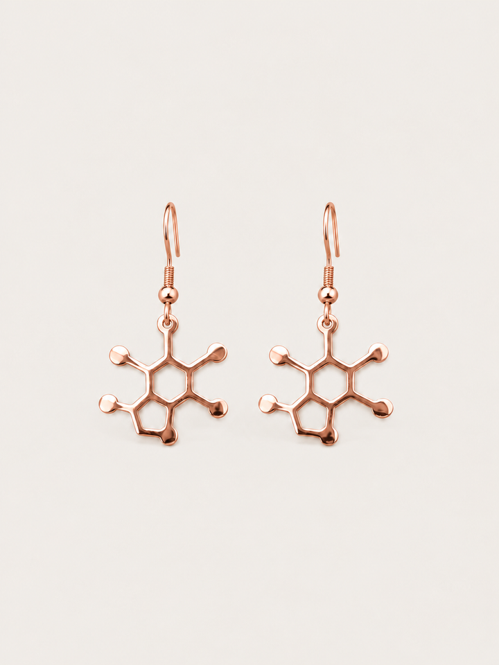 Rose Gold Caffeine Molecule Earrings shown on a warm neutral background