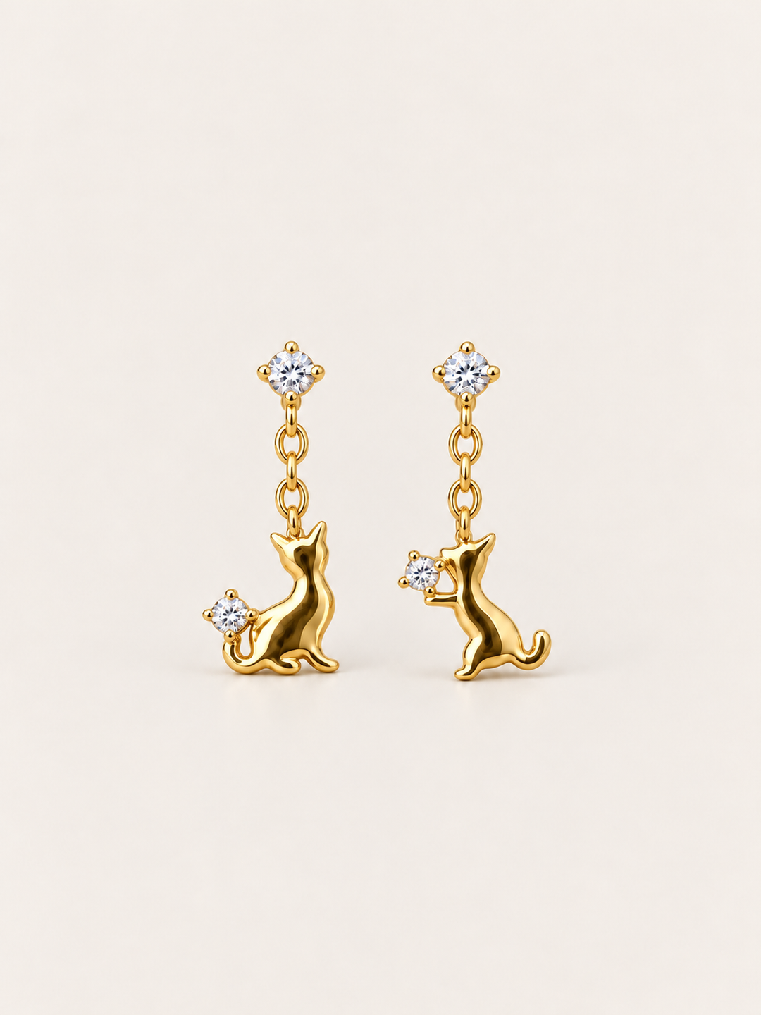 Gold Cat Crystal Drop Earrings shown on a warm neutral background