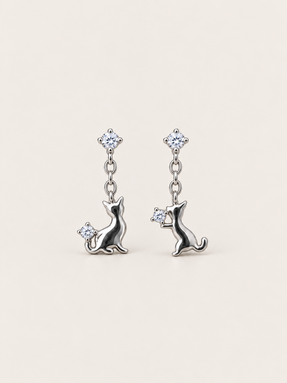 Silver Cat Crystal Drop Earrings shown on a warm neutral background