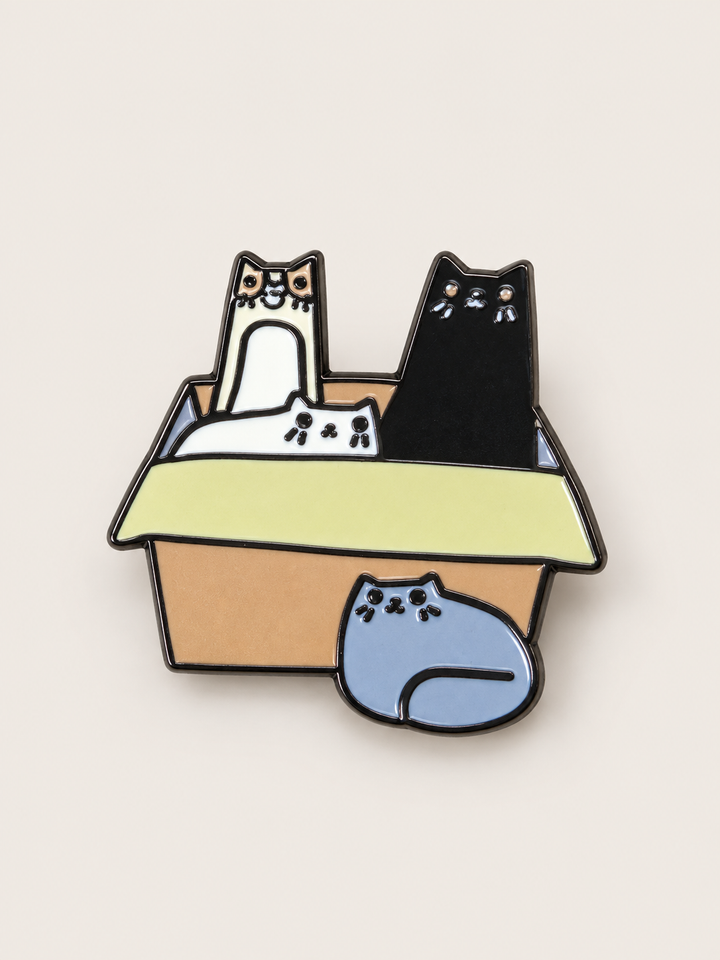 Cats in Cardboard Box Pin shown on a warm neutral background