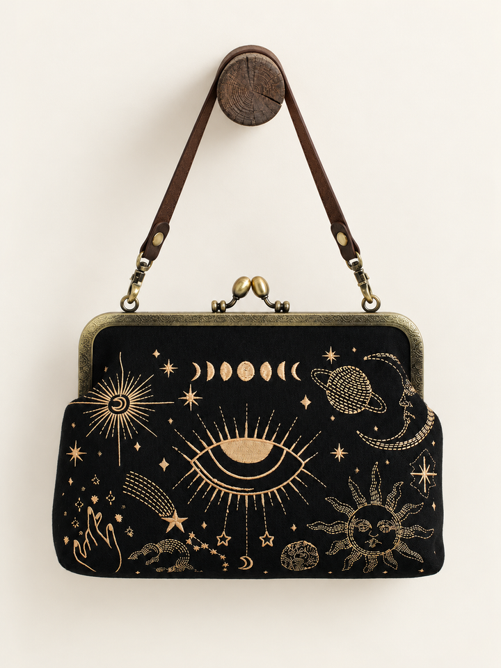 Celestial Kisslock Bag hanging from short vinyl strap