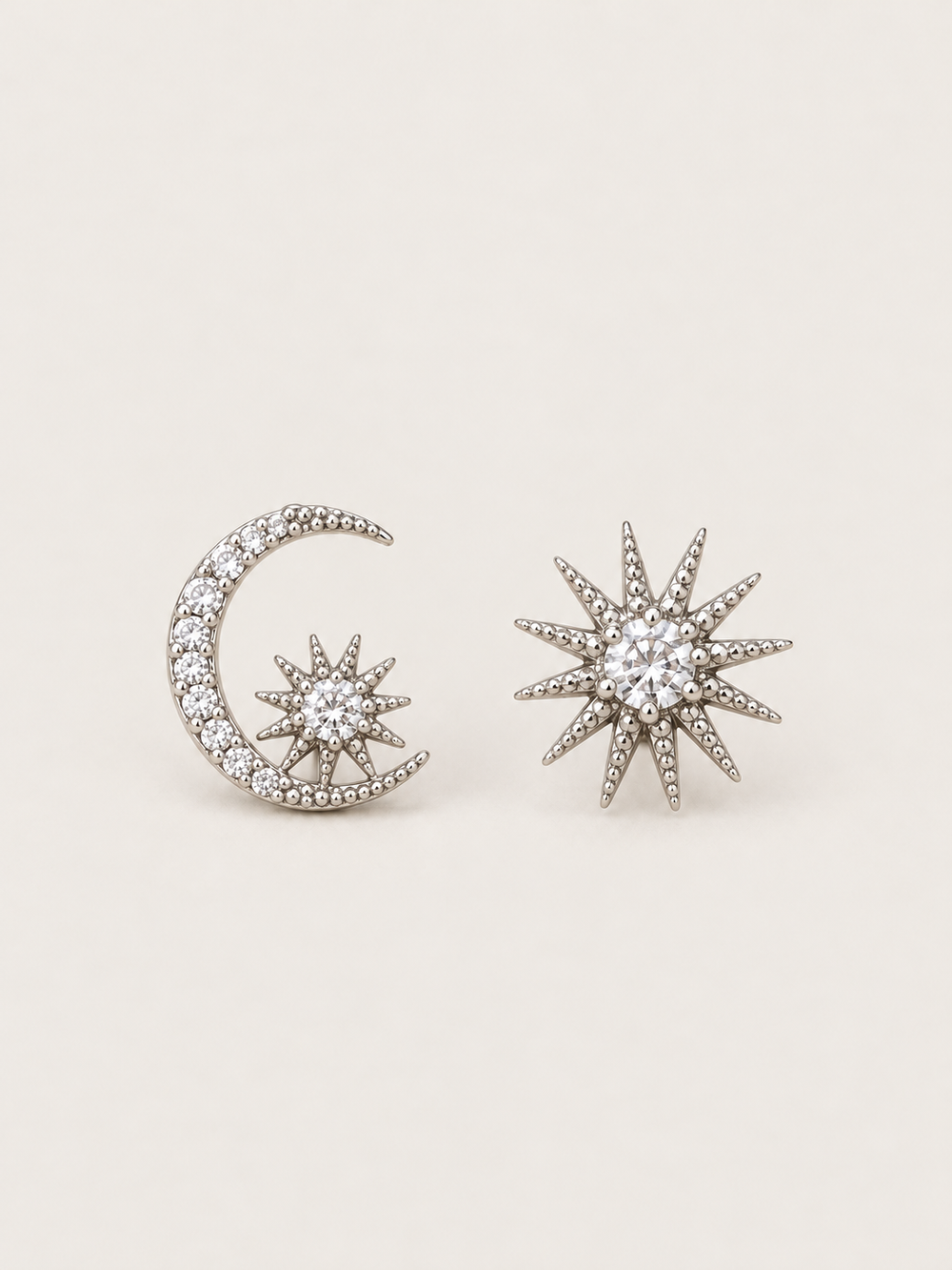 Silver Celestial Moon and Starburst Earrings shown on a warm neutral background