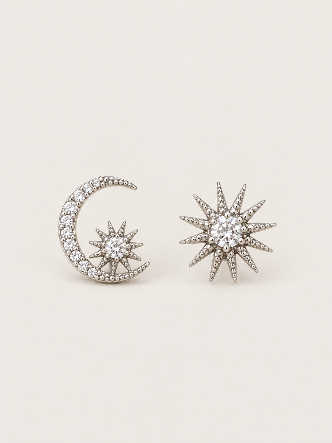 Silver Celestial Moon and Starburst Earrings shown on a warm neutral background
