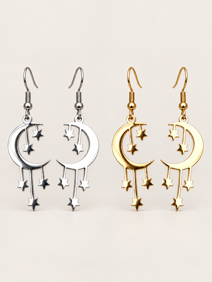 Silver and gold Crescent Moon and Stars Drop Earrings on a warm neutral background
