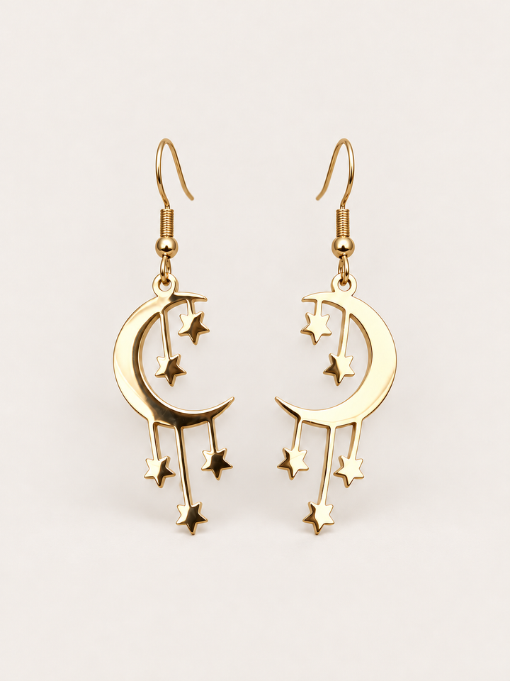 Gold Crescent Moon and Stars Drop Earrings on a warm neutral background