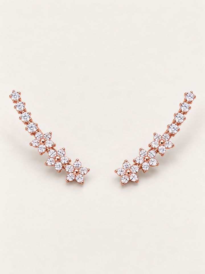 Rose gold Crystal Flower Ear Crawler Earrings on a warm neutral background