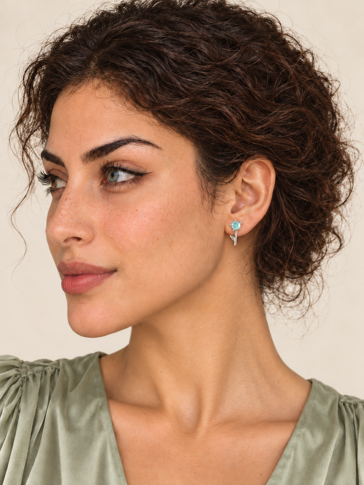 Crystal Flower Earrings with one stone and a leaf on a model's viewer-right ear