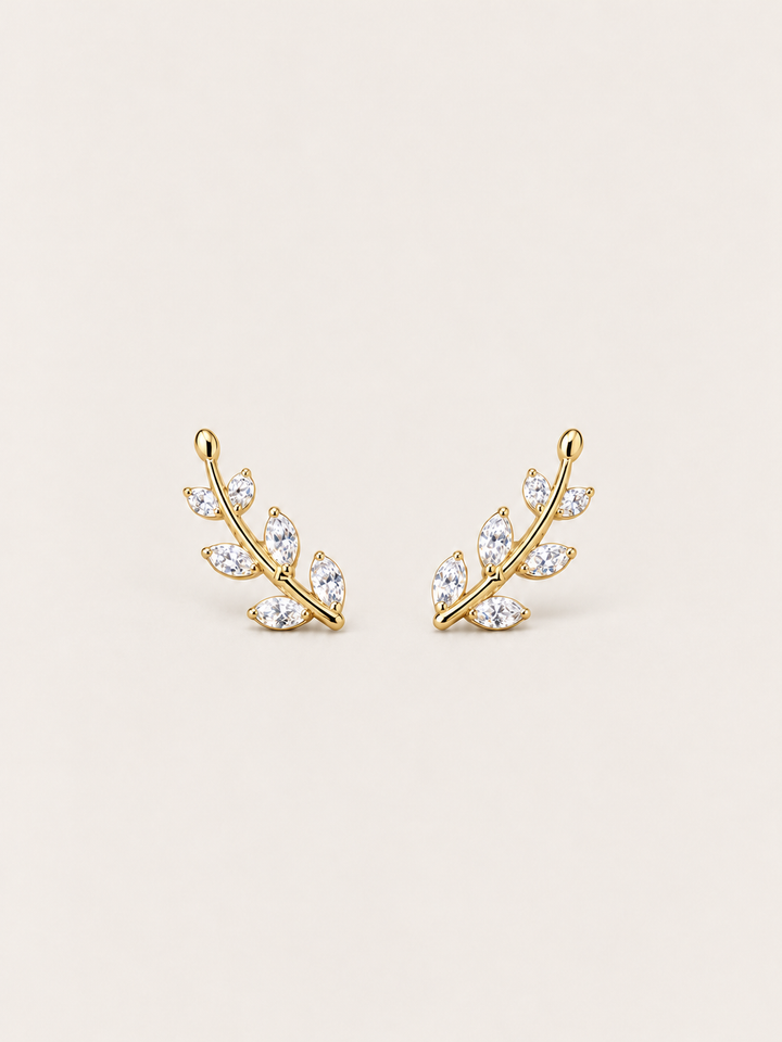 Crystal Leaf Ear Crawler Earrings in gold shown on a warm neutral background