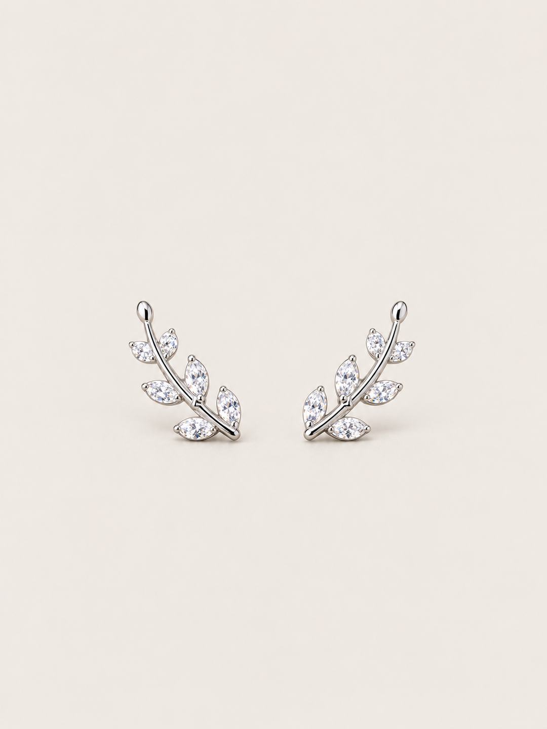 Crystal Leaf Ear Crawler Earrings in silver shown on a warm neutral background