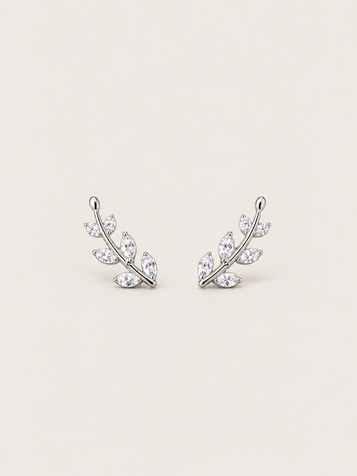 Crystal Leaf Ear Crawler Earrings in silver shown on a warm neutral background