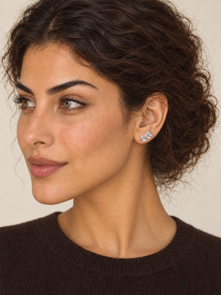 Silver Crystal Leaf Ear Crawler Earring worn on the viewer-right ear by a model in a dark brown sweater