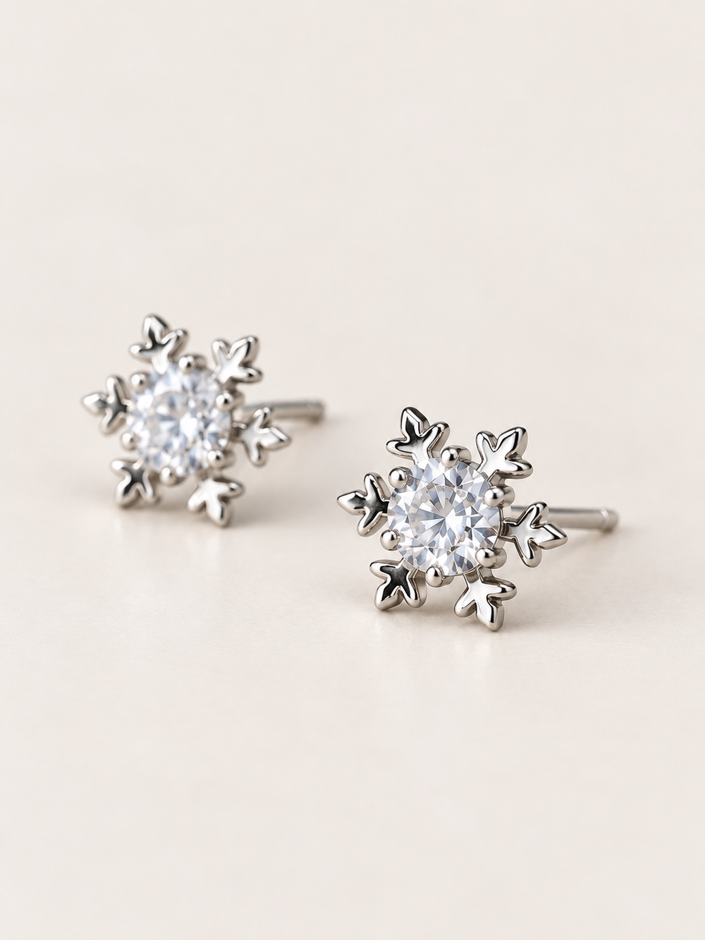 Crystal Snowflake Stud Earrings shown angled on a warm neutral background