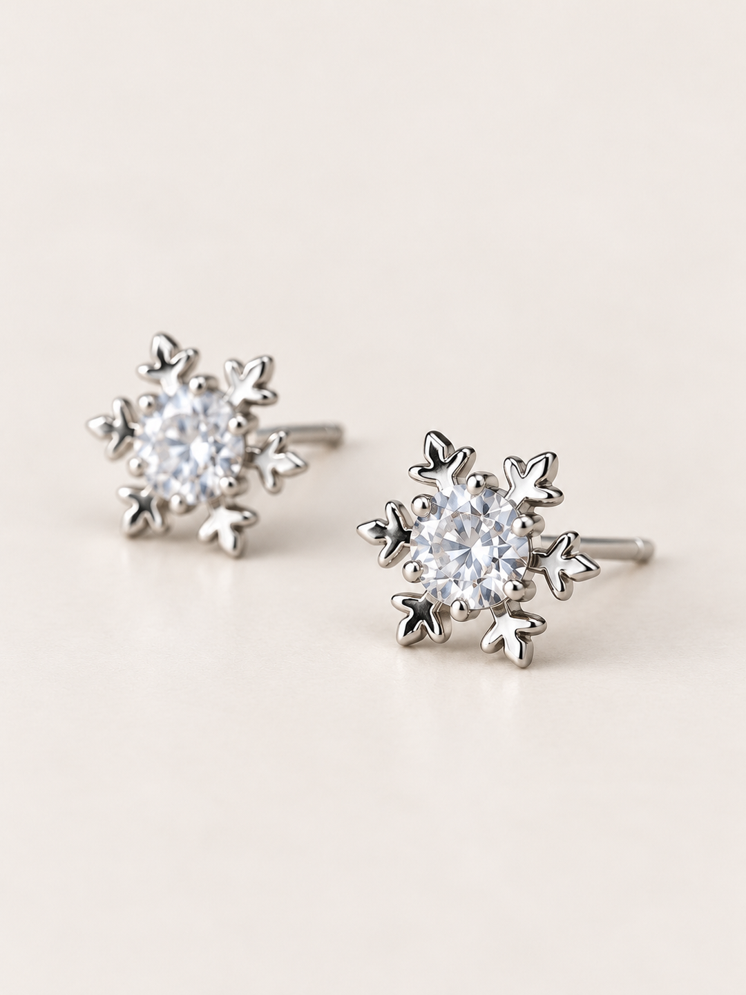 Crystal Snowflake Stud Earrings shown angled on a warm neutral background