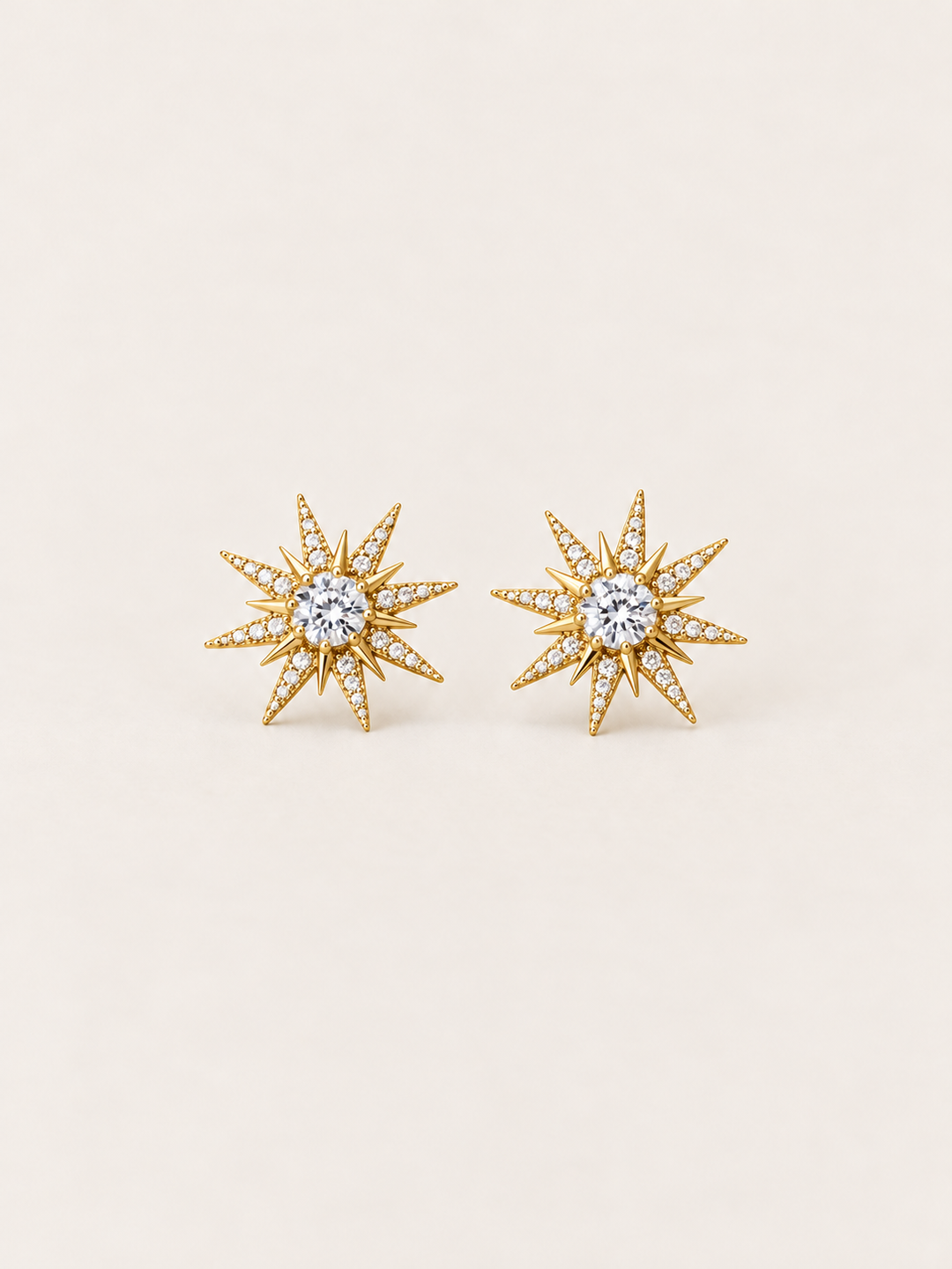 Crystal Starburst Stud Earrings in Gold shown on a warm neutral background