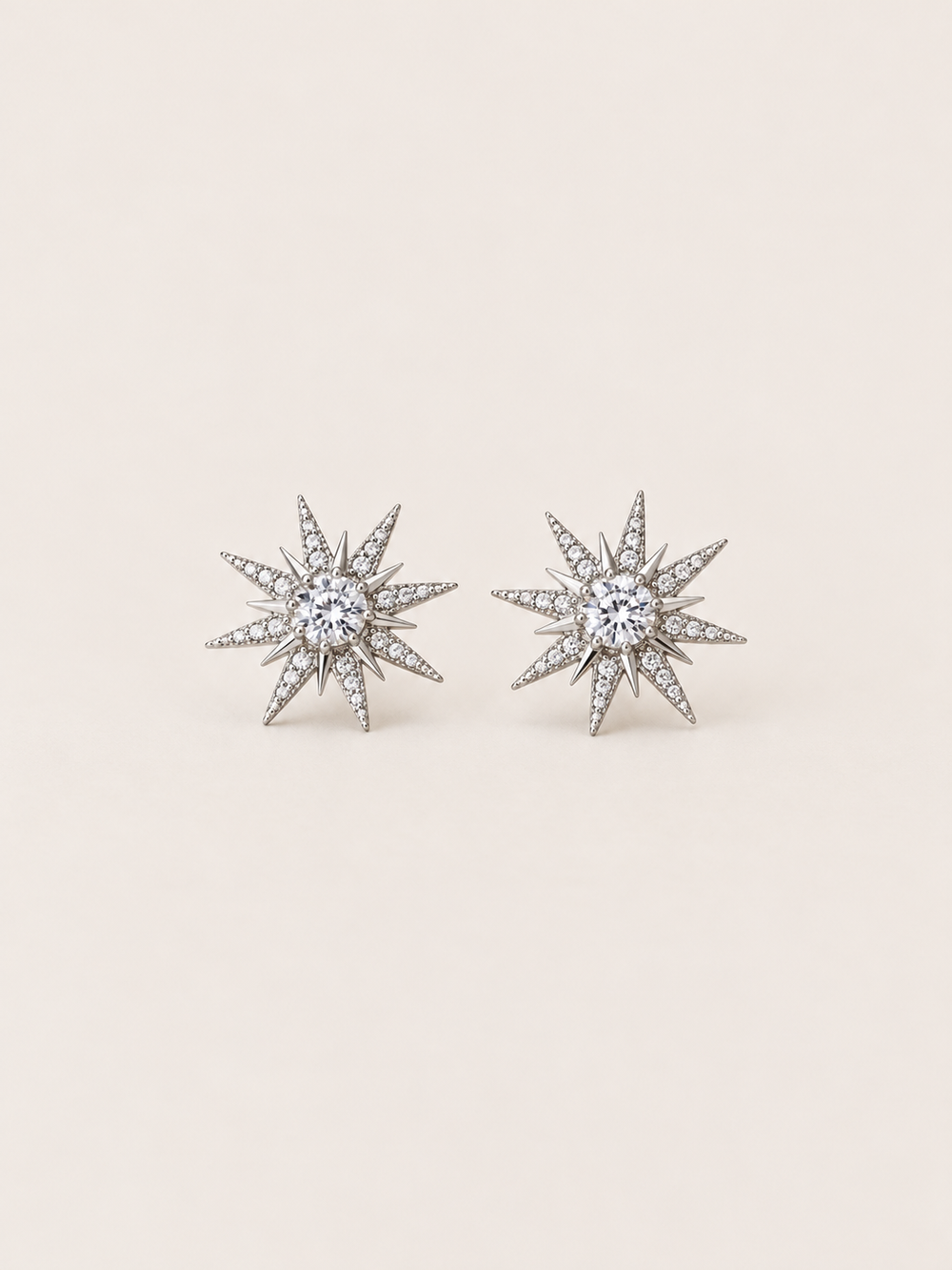 Crystal Starburst Stud Earrings in Silver shown on a warm neutral background