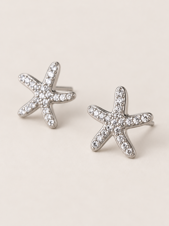 Silver Crystal Starfish Stud Earrings shown angled on a warm neutral background