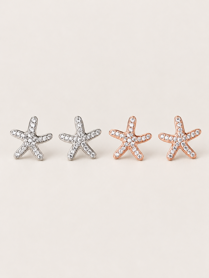 Crystal Starfish Stud Earrings in Silver and Rose Gold shown on a warm neutral background