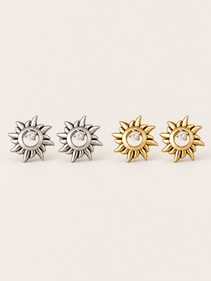 Crystal Sun Stud Earrings in silver and gold shown on a warm neutral background