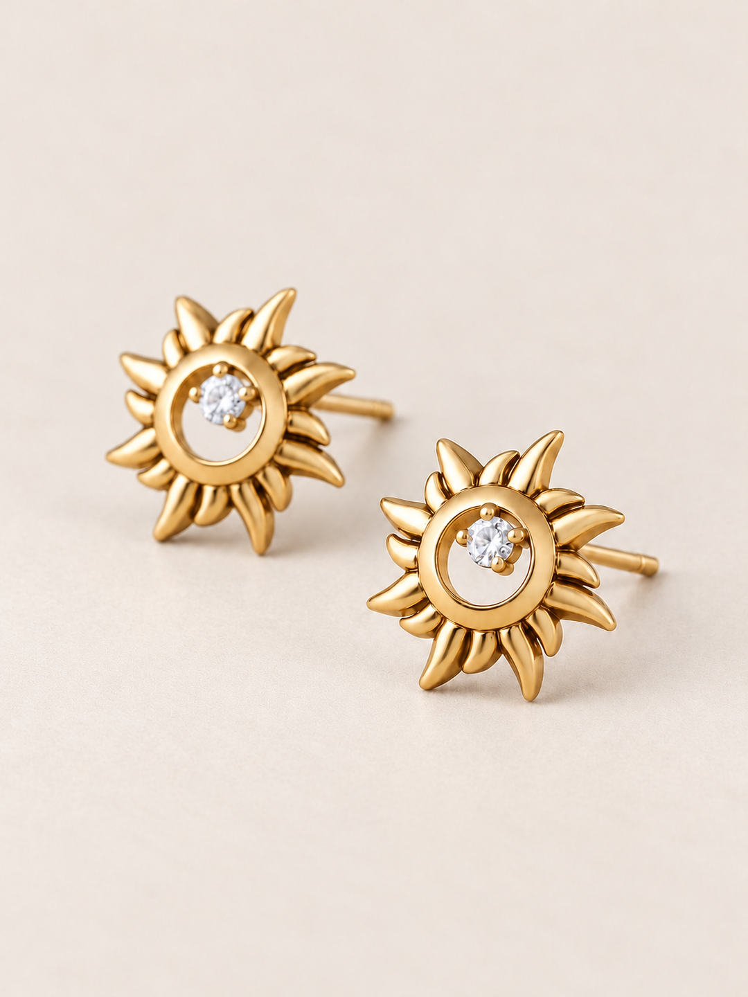 Gold Crystal Sun Stud Earrings shown angled on a warm neutral background