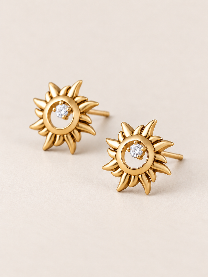 Gold Crystal Sun Stud Earrings shown angled on a warm neutral background