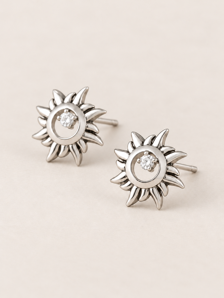 Silver Crystal Sun Stud Earrings shown angled on a warm neutral background