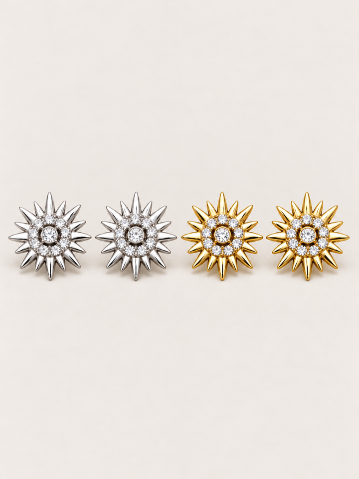 Crystal Sunburst Stud Earrings in Silver and Gold on a warm neutral background