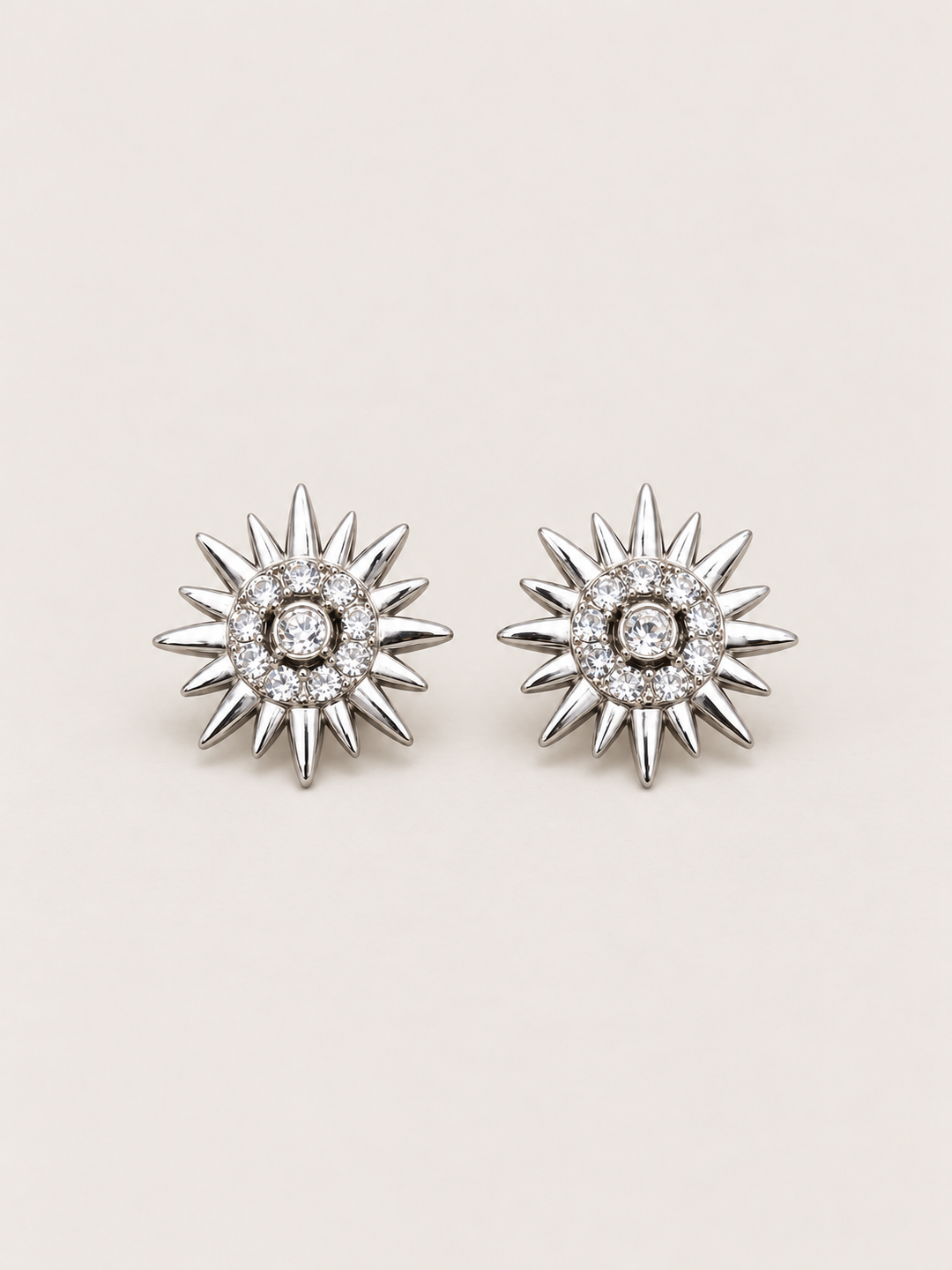 Crystal Sunburst Stud Earrings in Silver shown on a warm neutral background