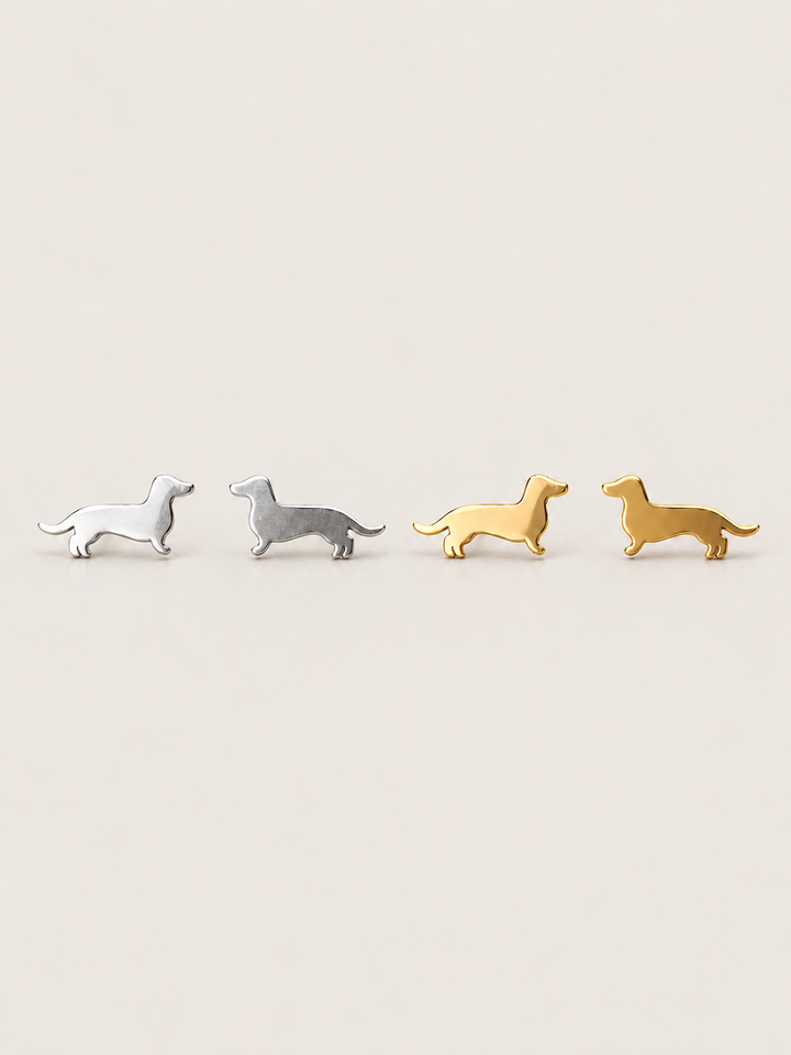 Dachshund Stud Earrings in silver and gold shown on a warm neutral background
