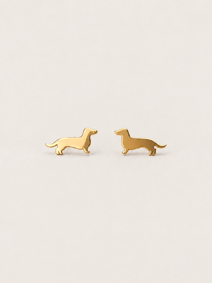 Dachshund Stud Earrings in gold shown on a warm neutral background