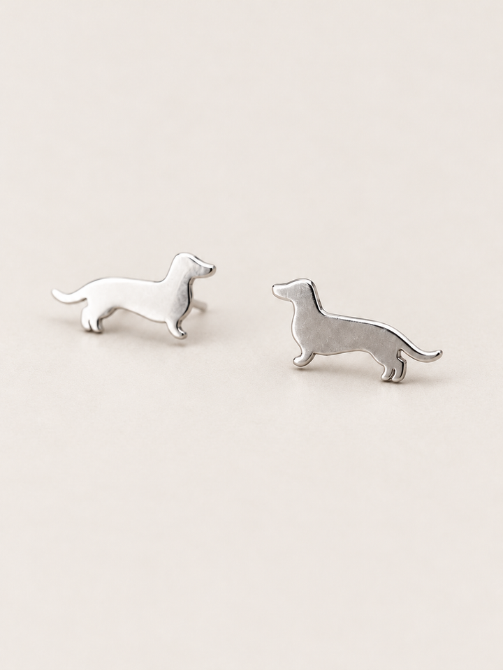 Dachshund Stud Earrings in silver shown angled on a warm neutral background