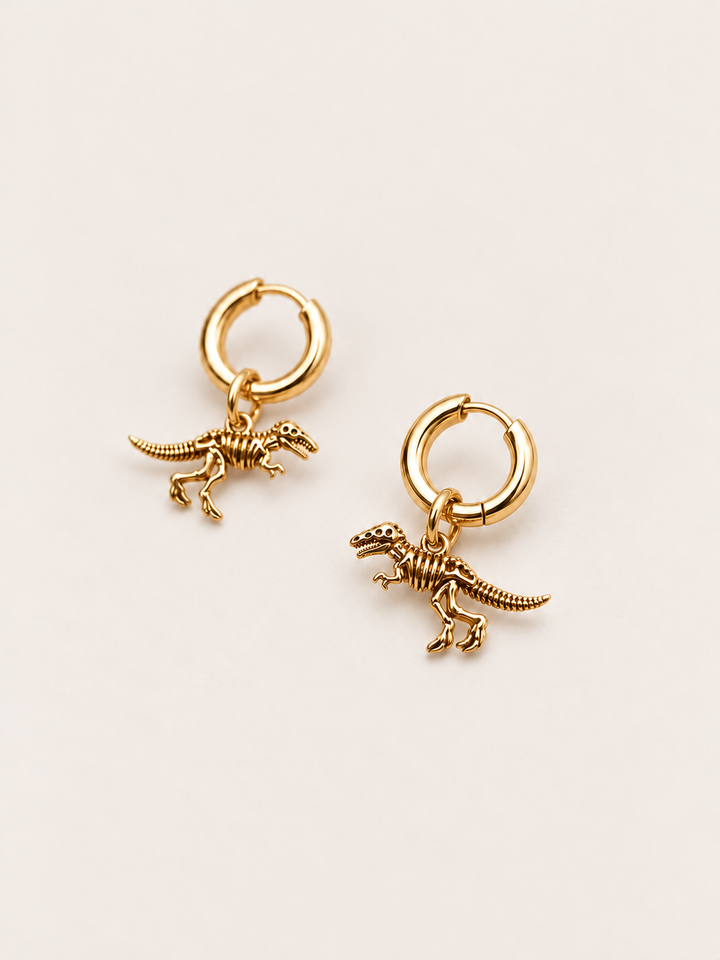 Dinosaur Skeleton Hoop Earrings — gold angle on a warm neutral background