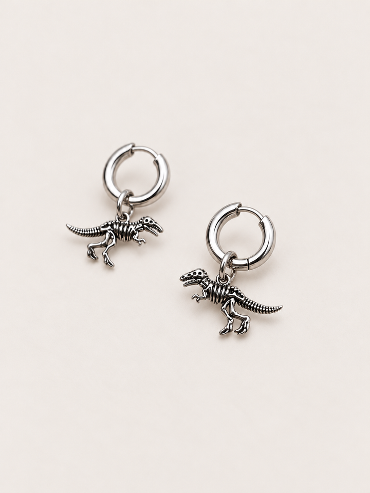 Dinosaur Skeleton Hoop Earrings — silver angle on a warm neutral background