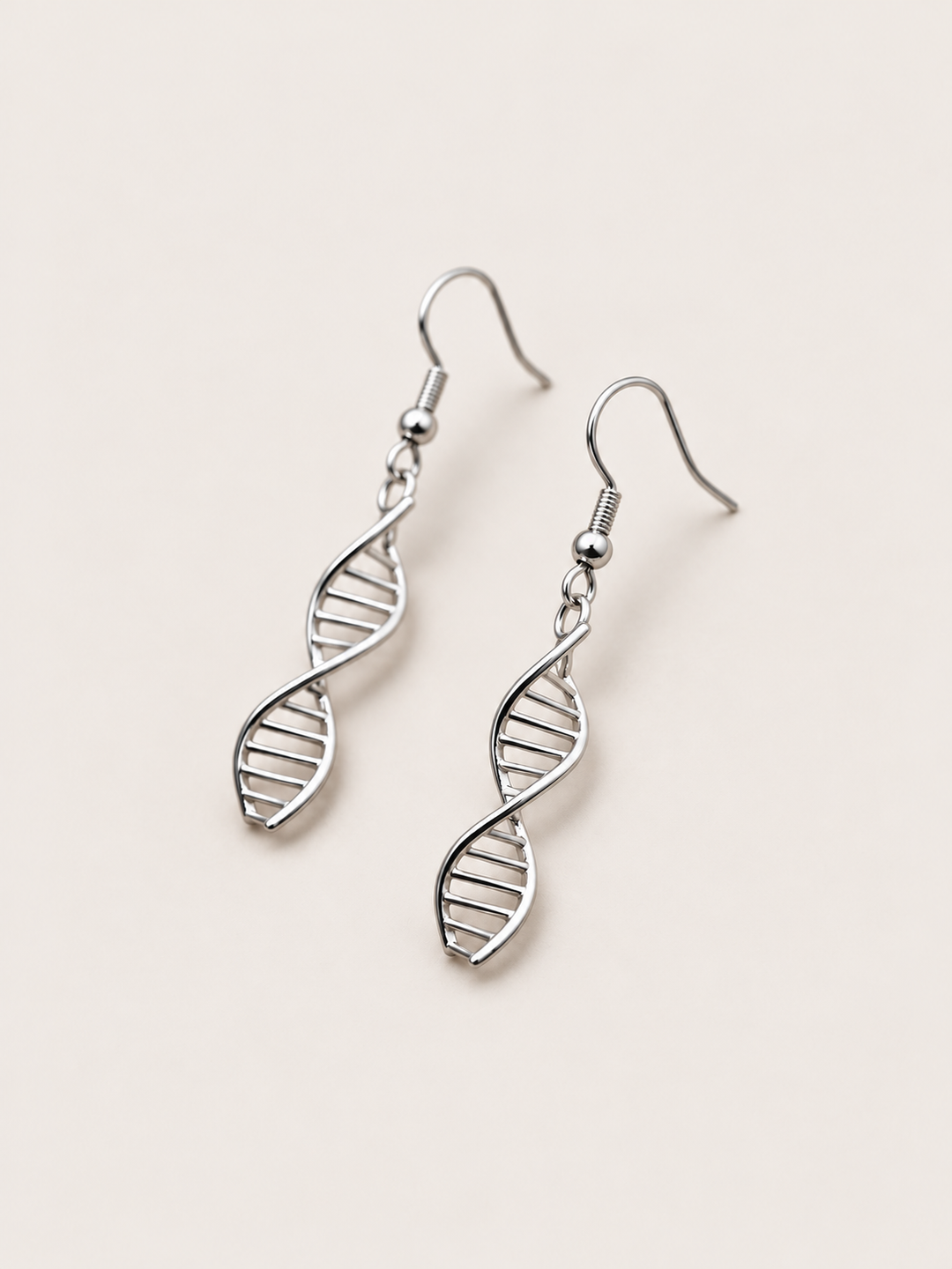 Silver DNA Double Helix Earrings shown angled on a warm neutral background